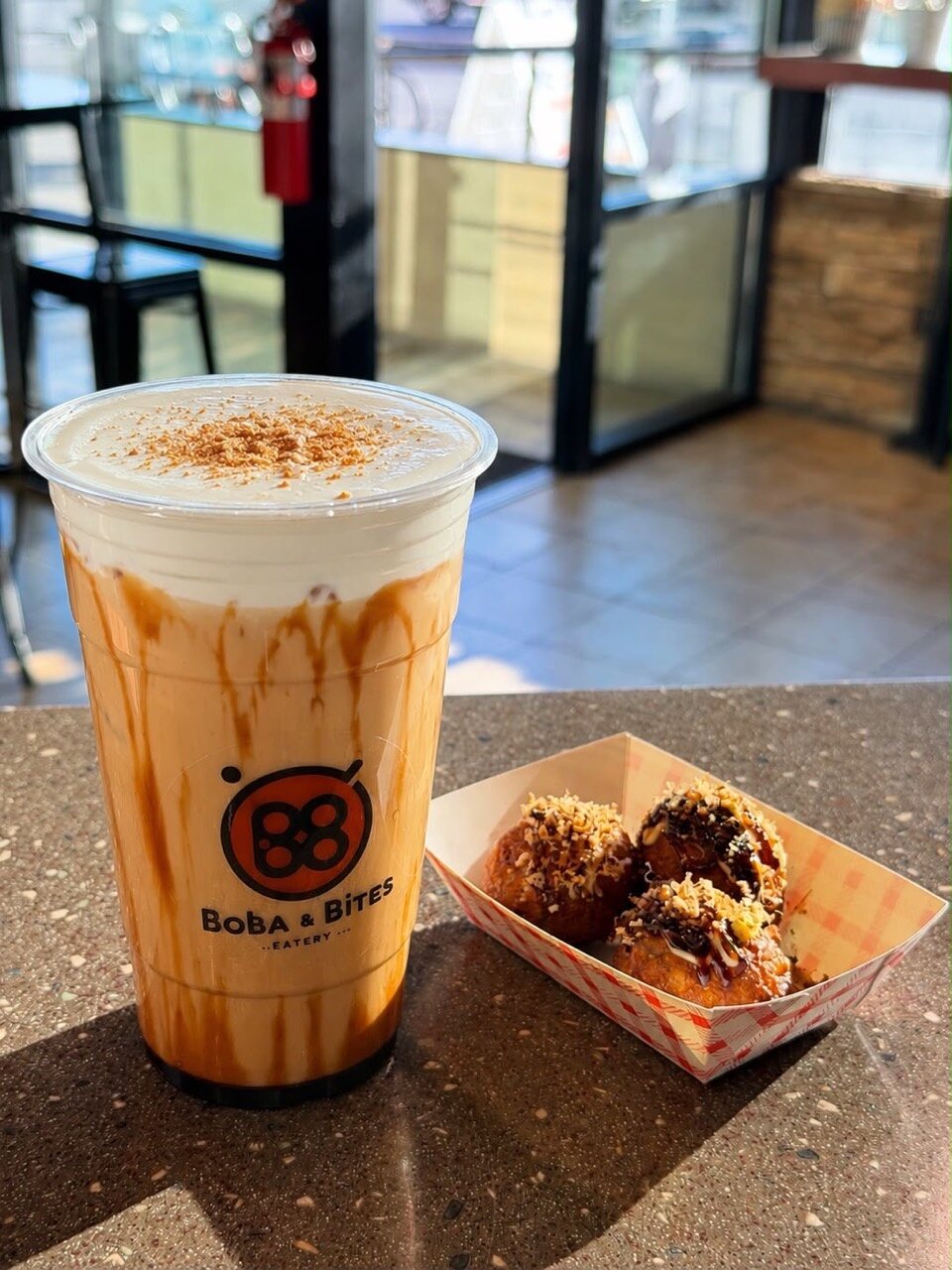 A Boba & Bites milk tea and takoyaki inside the shop